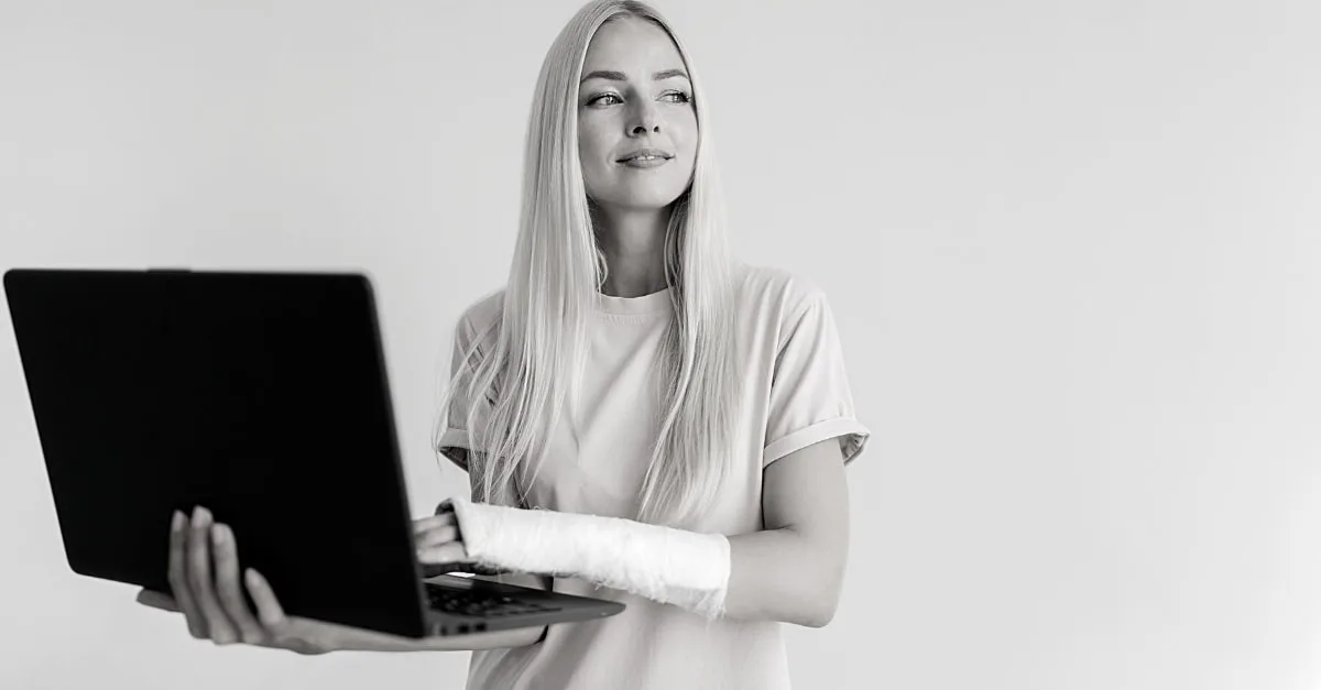 En pige med brækketarm, som holder en bærbar computer