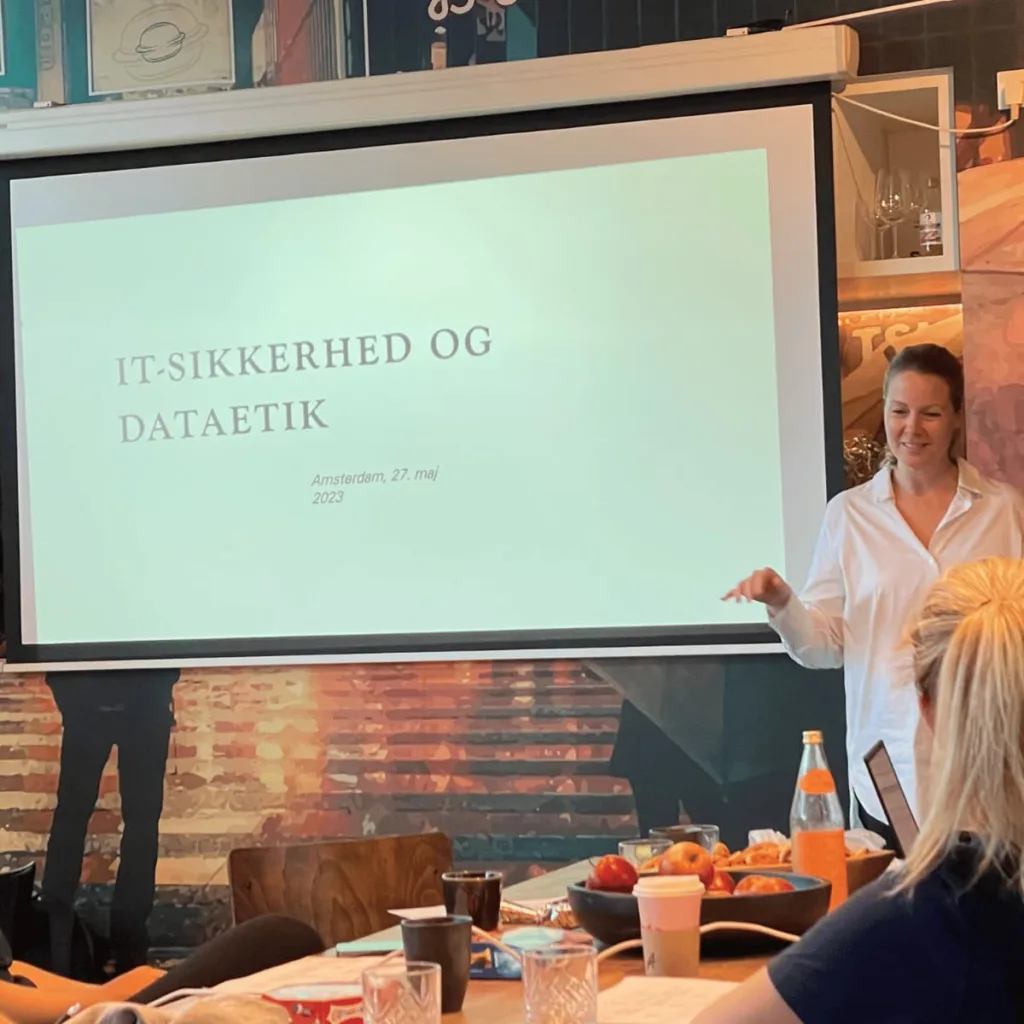En kvinde står ved en tavle med skriften it-sikkerhed og dataetik
